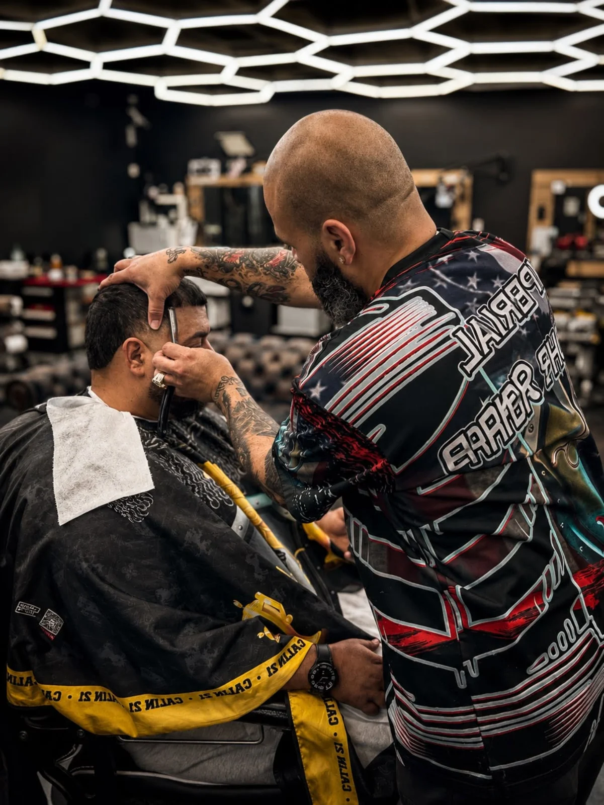 Barber detailing a customer’s hairline with a straight razor.
