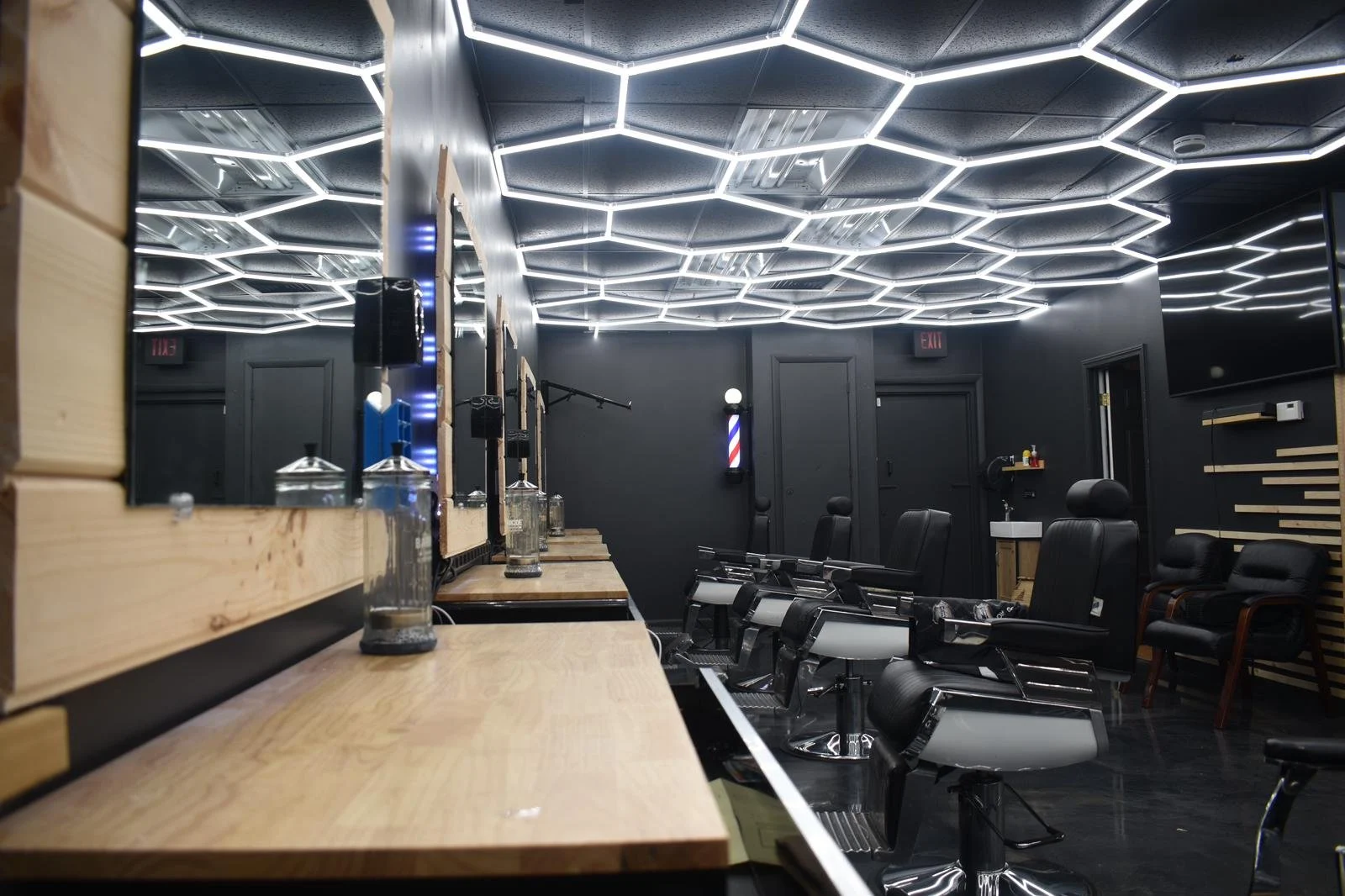 Inside Imperial Barbershop, with black barber chairs and geometric ceiling lights.